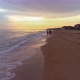 Man and woman walk along the beach in the evening at sunset. - VideoHive Item for Sale