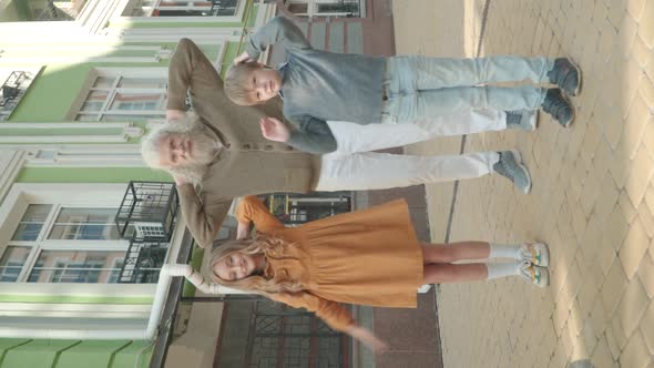 Vertical Video, Funny Dance of Cheerful Multigenerational Family on City Street. Wide Shot Portrait
