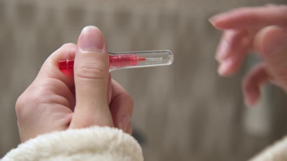 Closeup of Female Hands with an Interdental Brush in the Bathroom Against the Background of the Sink