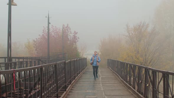 Girl in Headphones Jogging on Foggy Morning