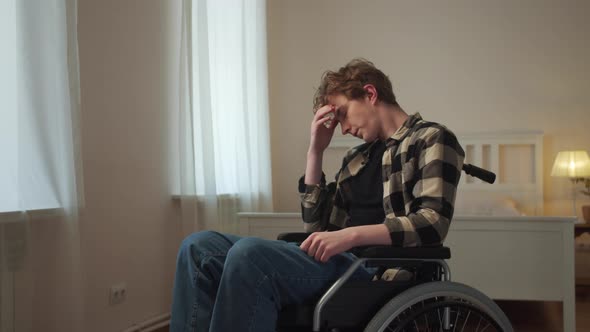 A Young Disabled Man is Riding in His Wheelchair Around the Room