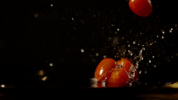 Cherry tomatoes falling in water, Ultra Slow Motion