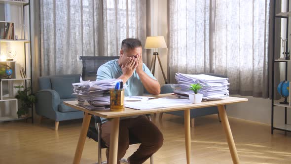 Fat Asian Man Being Tired Working Hard With Documents At The Office