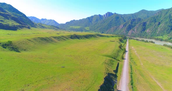 Aerial Rural Mountain Road and Meadow at Sunny Summer Morning