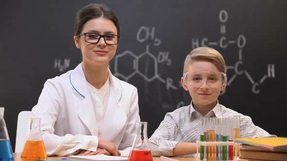 Little Boy and Teacher Looking Into Camera at Chemistry Lesson, Laboratory