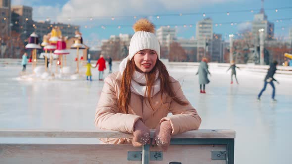 Young Smiling Woman Ice Skating Outside on Ice Rink Show Thumbs Up Gesture Christmas Holiday Active