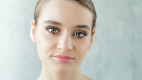 Beautiful Young Woman with Clean and Healthy Skin Posing on Grey Background