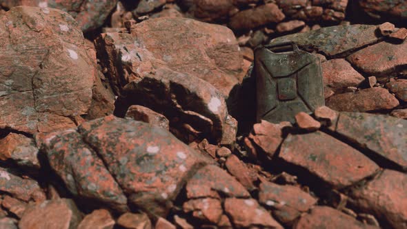 Old Rusty Metal Canister for Gasoline Fuel at Rocks