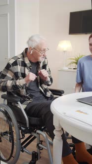 A Woman From Social Care Plays an Elderly Wheelchair User His Favorite Music