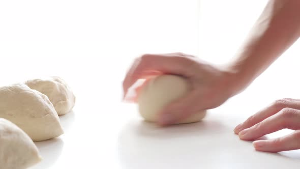 Hand knead dough on table professional way on white background 4K 2160p 30fps UltraHD footage - Knea
