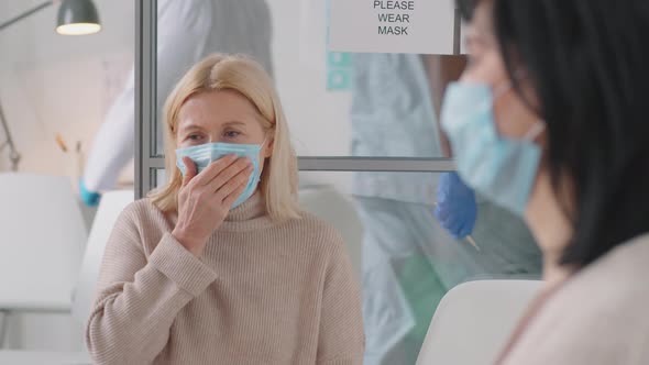 Female Patient in Protective Mask Coughing in Hospital