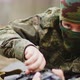 Closeup of a Masked Soldier Preparing to Fire and Pointing the Machine Gun Towards the Camera - VideoHive Item for Sale