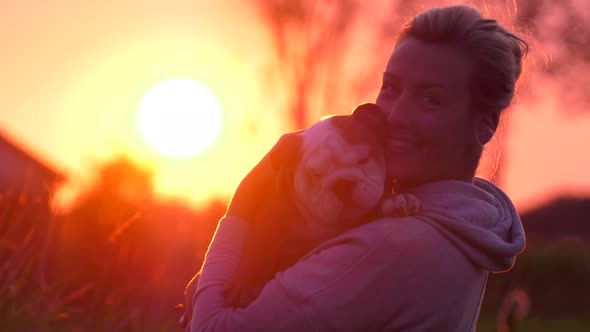 beautiful girl and puppy bulldog in hot sunset looking cute 4k