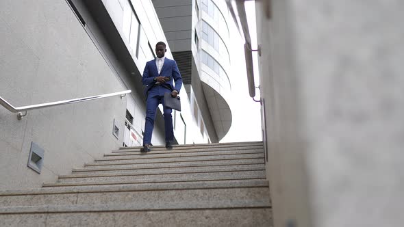 Businessman with laptop bag walking downstairs