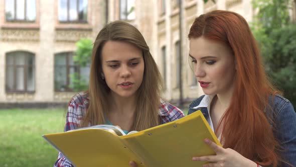 Female Student Points Her Forefinger Into the Journal Outdoors