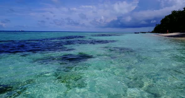 Beautiful fly over abstract shot of a white paradise beach and blue sea background in vibrant