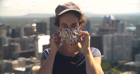 Midadult Woman Removing Mask with Cityscape