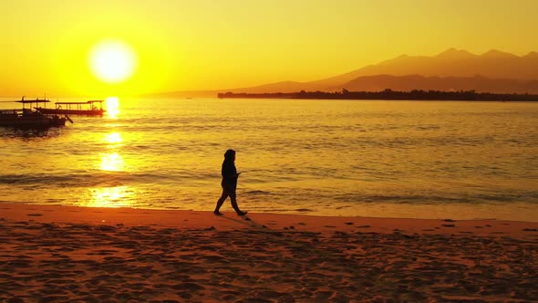 Single lady sunbathing on beautiful coast beach trip by aqua blue ocean and white sandy background o