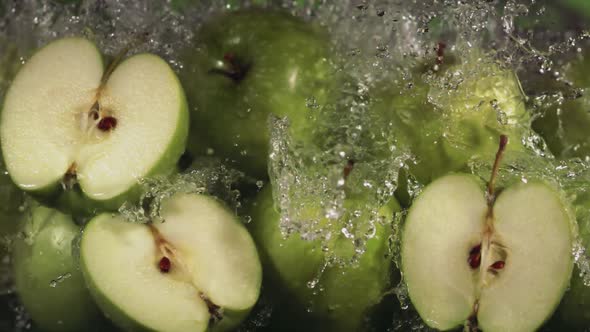 Slow Motion Shot of Green Apple Water Splashing Through Apple Slices