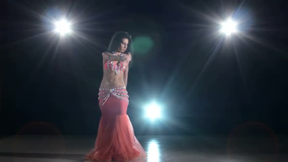 Long-haired Belly Dancer Girl Dancing Exotic Dance Movement on Black, Back Light