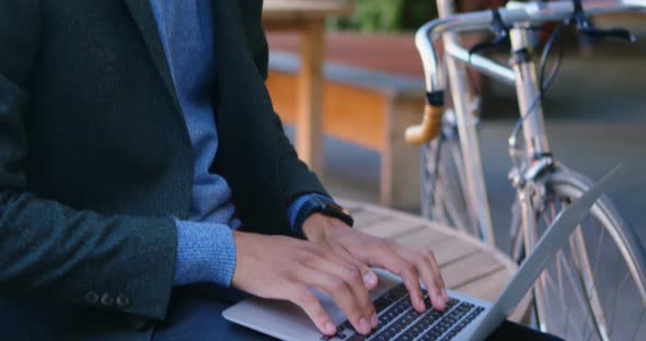 Businessman using laptop on street 4k