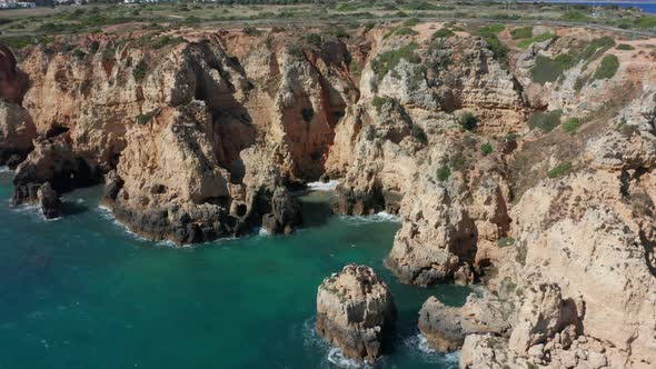 Stunning aerial of a beautiful blue sea with eroded cliffs on shore