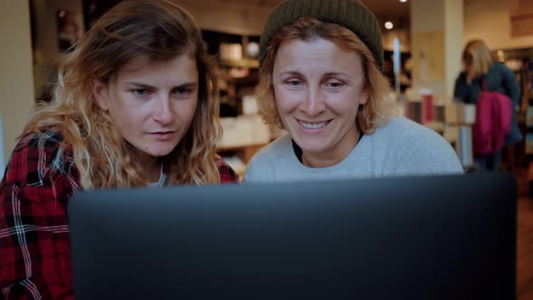Two Women Work on Laptop in Cafe or Coworking
