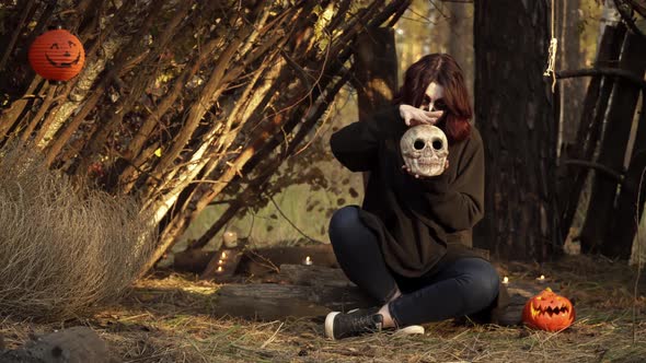 Witch with Sugar Skull Makeup Holds Skull and Moves Hand Around It