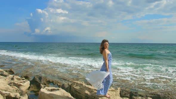 Beautiful Brunette Woman in Maxi Dress Enjoying Windy Day on Seashore, Vacation