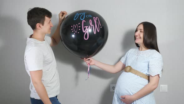 Young Parents Find Out the Gender of Their Unborn Child By Popping a Balloon with Blue Confetti