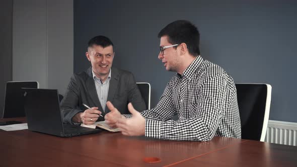 Men Making Agreement at Table in Office