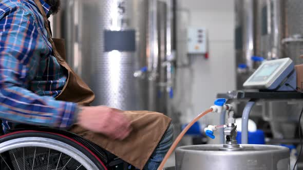 Man in Wheel Chair Working in Brewery Factory