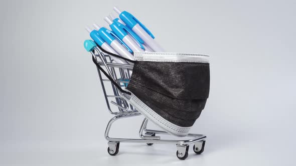 Shopping cart with a bunch of blue white ballpoint pens with buttons 