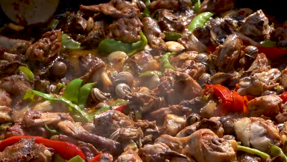 a metal ladle mixes a typical Spanish dish, close up slow motion shot