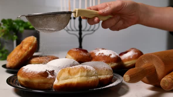 Spreading Sugar Powder On Hanukkah Doughnuts