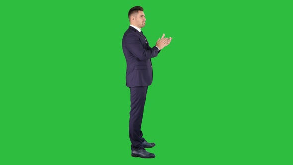 Business man clapping hands on a Green Screen, Chroma Key.