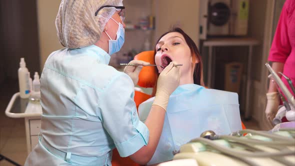 Dentist Finishing Checkingup Teeth of a Young Woman