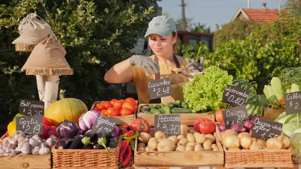 A Farmer Girl Puts Organic Vegetables in a Paper Bag