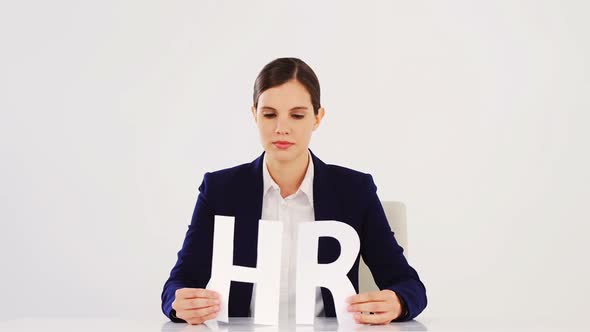 Businesswoman holding paper cut out of HR sign