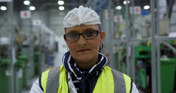 Warehouse female worker looking at camera with arms crossed