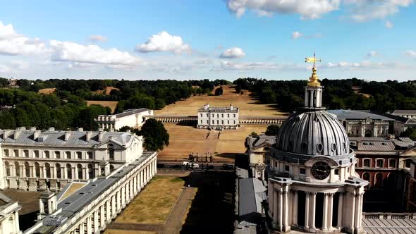 Drone shot above London's Greenwich Old Royal Naval College flying towards the park.