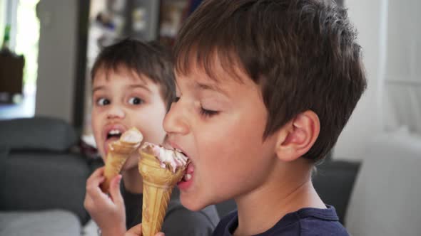 Close up isolated shot of two caucasian boys, enjoying ice cram cones at home 4K