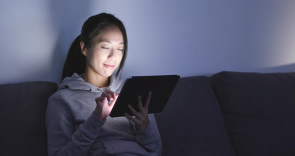 Woman use of tablet computer at night