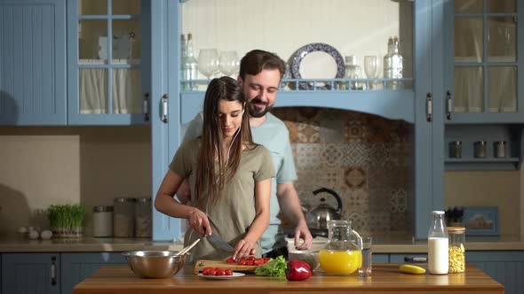 Portrait of Beautiful Housewife Listening to Music Using Earphones and Cutting Healthy Salat with