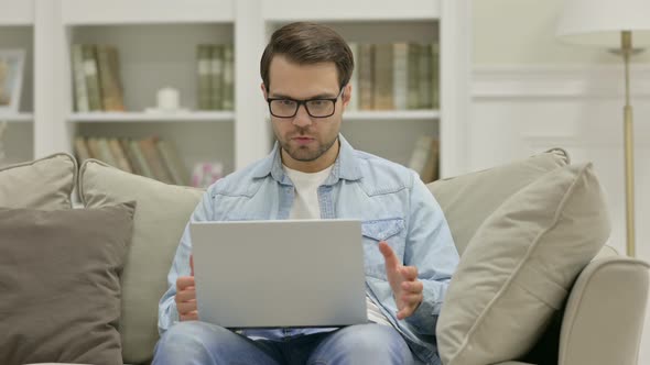 Young Man Reacting To Loss on Laptop at Home