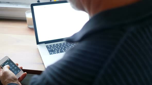 Man using laptop and mobile phone in living room 4k