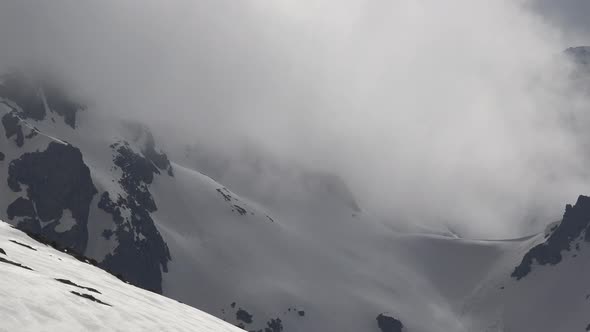 Passage in Gloomy Deep Valley Between Snowy Steep Mountains