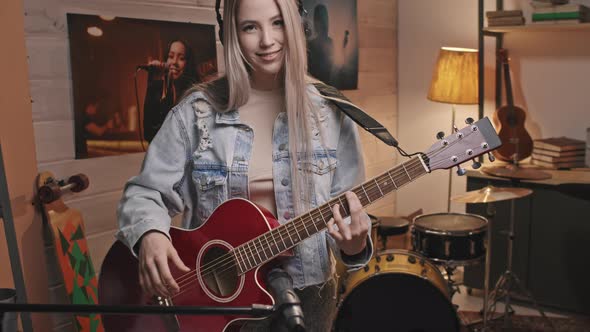 Portrait Of Young Smiling Female Guitarist