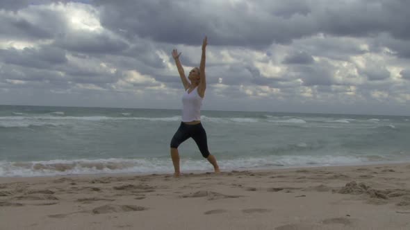 Female practising yoga on a beach