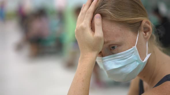 Sick Young Woman Sitting in a Hospital Waiting for Doctor's Appointment